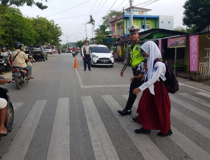 Demi Keselamatan, Personil Satlantas Polres Paser Bantu Seberangkan Anak Sekolah 1 1